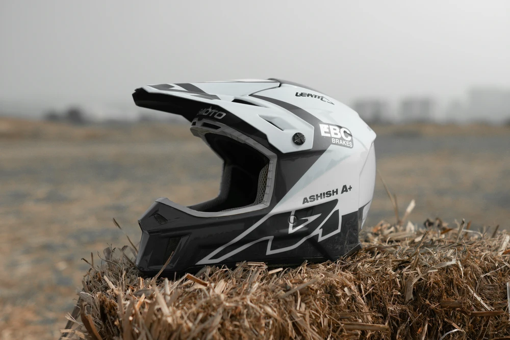 Motocross helmet placed next to a dirt track